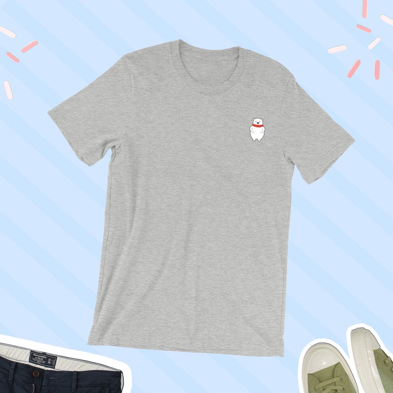 May include: A heather gray t-shirt with a small white polar bear wearing a red scarf embroidered on the left chest.