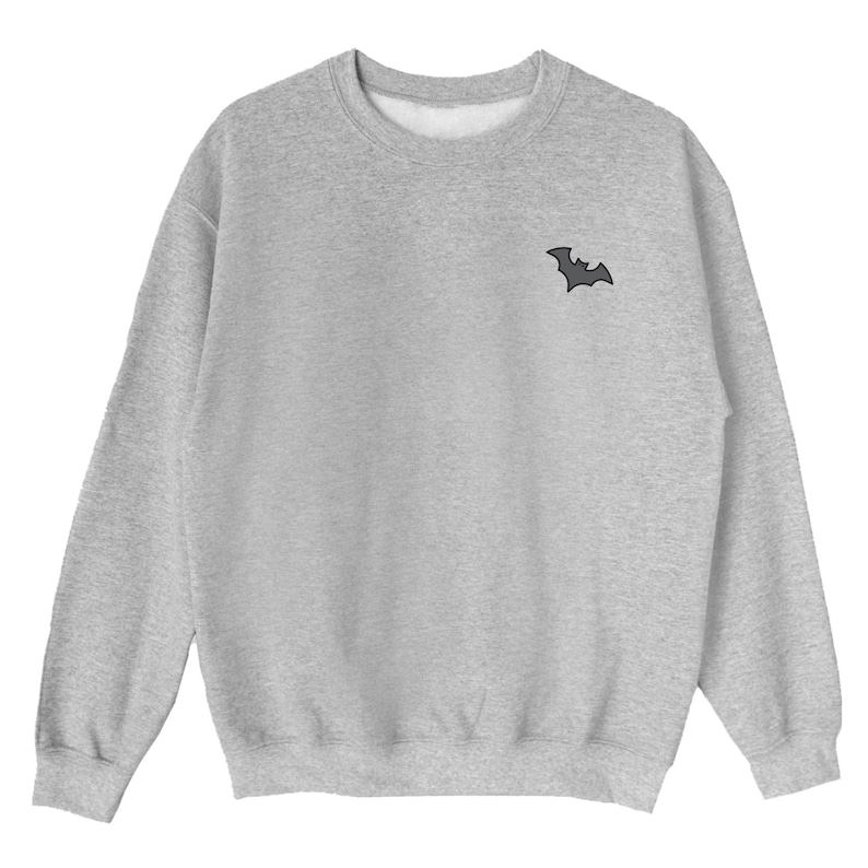 May include: A gray sweatshirt with a small black bat graphic on the left chest.