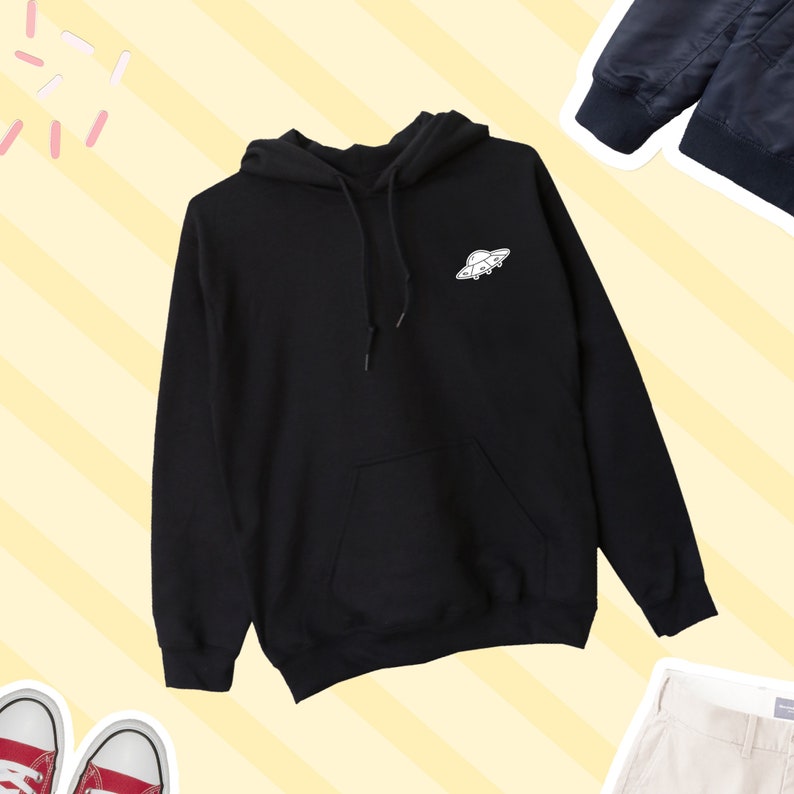 K&ouml;nnte beinhalten: Schwarzer Kapuzenpullover mit einem wei&szlig;en UFO-Motiv auf der Vorderseite.