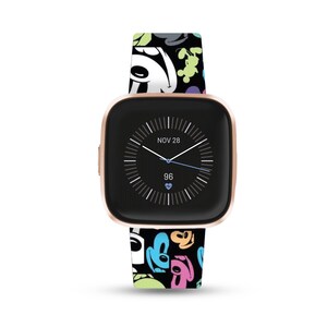 May include: A rose gold smartwatch with a black face and a white watch band with a colorful Mickey Mouse print. The watch face displays the date "NOV 28" and the time. The watch face also displays a heart rate of 96.