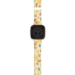 K&ouml;nnte beinhalten: Ein gelbes Armband mit einem Muster von Belle aus Die Sch&ouml;ne und das Biest. Das Zifferblatt der Uhr zeigt das Datum "NOV 28" und die Zeit "96".