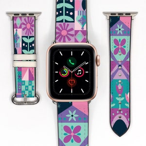 Op de afbeelding: Een kleurrijk, gepatroneerd Apple Watch bandje met een geometrisch ontwerp in roze, paars, groen en blauw. Het bandje wordt getoond met een gouden Apple Watch.