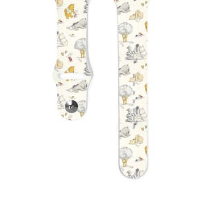 Op de afbeelding: Witte Apple Watch band met een Winnie de Poeh en vrienden print. De band heeft personages zoals Winnie de Poeh, Biggetje, Eeyore, Teigetje en een zebra.