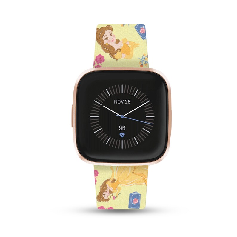 K&ouml;nnte beinhalten: Eine ros&eacute;goldene Fitbit Smartwatch mit einem gelben und rosafarbenen Armband mit Belle aus Disneys Die Sch&ouml;ne und das Biest. Das Zifferblatt der Uhr zeigt das Datum "NOV 28" und eine Herzfrequenz von 96.