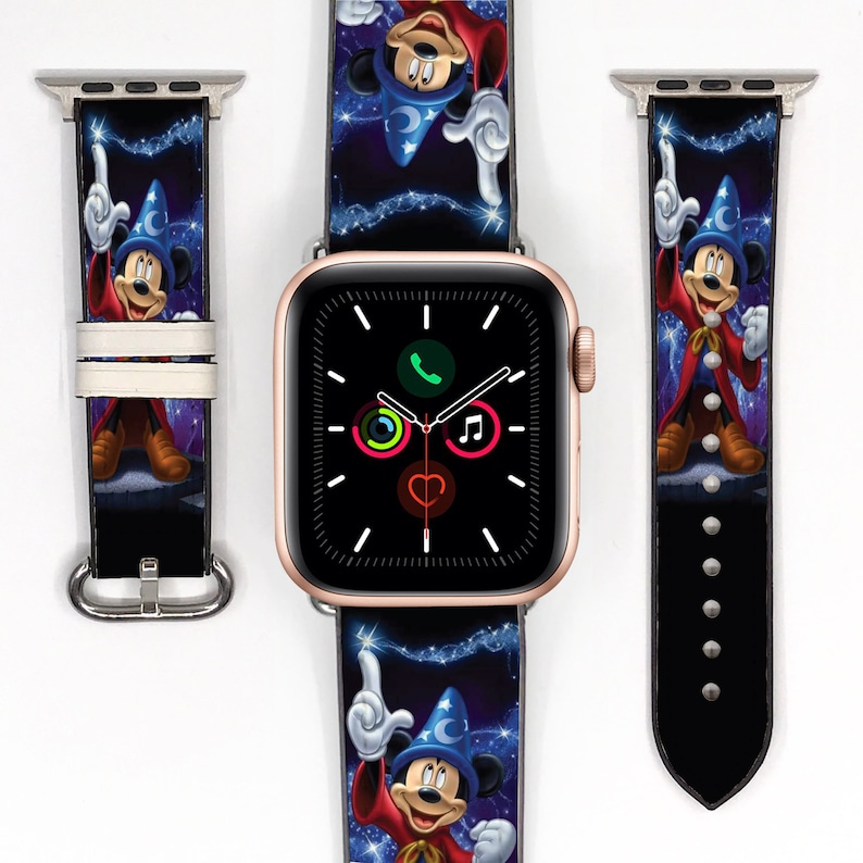 Op de afbeelding: Een zwart en blauw Apple Watch bandje met een kleurrijk beeld van Mickey Mouse als tovenaar. Het bandje is van leer en heeft een gouden gesp.