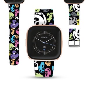 May include: A black and white watch band with a colorful Mickey Mouse pattern. The band is shown on a rose gold smartwatch with a black face. The watch face displays the date "NOV 28" and the time "96".