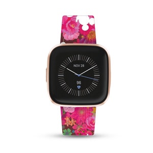 K&ouml;nnte beinhalten: Eine ros&eacute;goldene Smartwatch mit schwarzem Zifferblatt und einem pinkfarbenen Armband mit floralem Muster. Das Zifferblatt zeigt das Datum "NOV 28" und die Uhrzeit an. Die Herzfrequenz wird als "96" angezeigt.