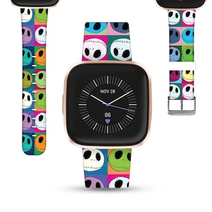Puede incluir: Un smartwatch de color oro rosa con una esfera negra y una banda estampada de colores con el personaje Jack Skellington de la película Pesadilla antes de Navidad. La esfera del reloj muestra la fecha "NOV 28" y la hora 96.