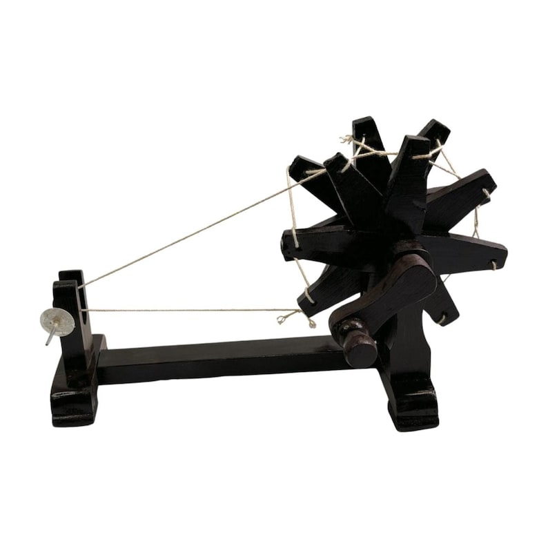Angled view of a dark brown handcrafted Gandhi charkha spinning wheel, tabletop khadi decor.