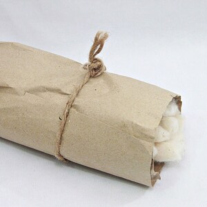 May include: A roll of white cotton wrapped in brown paper and tied with twine.