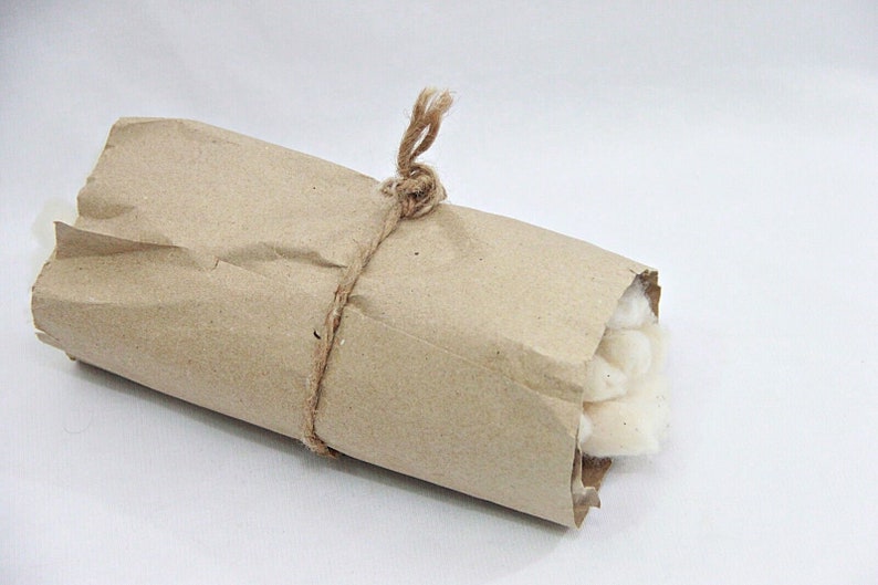 May include: A roll of white cotton wrapped in brown paper and tied with twine.