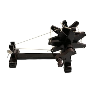 Three quarter close angle showing spokes and thread path on a Gandhi charkha spinning wheel.