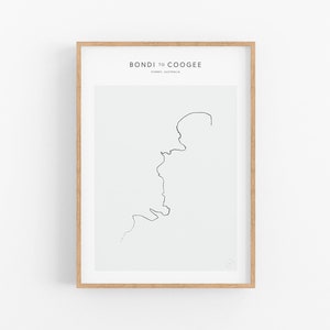 Puede incluir: Una impresión enmarcada con un dibujo de línea minimalista de la costa desde Bondi hasta Coogee en Sydney, Australia. El texto "BONDI TO COOGEE" y "SYDNEY, AUSTRALIA" está impreso en negro en la parte superior de la impresión.