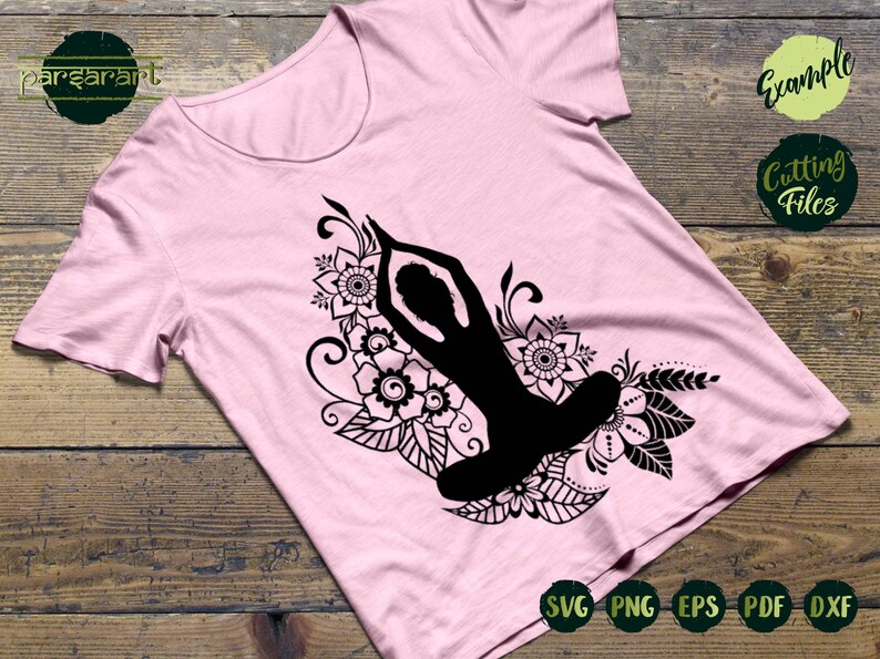 May include: A black silhouette of a person in a yoga pose surrounded by intricate floral designs. The design is on a pink t-shirt. The words "SVG PNG EPS PDF DXF" are visible at the bottom of the image.