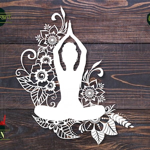 May include: White silhouette of a person in a yoga pose surrounded by intricate floral designs. The design is perfect for creating cut files for crafts.
