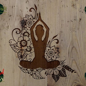 May include: A black silhouette of a person in a yoga pose surrounded by intricate floral designs. The image is set against a woodgrain background.