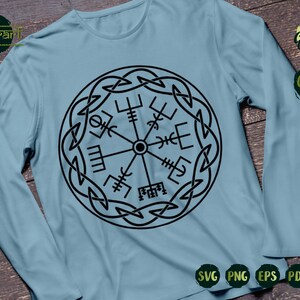 May include: A light blue long-sleeved t-shirt with a black and white compass design. The compass is surrounded by a Celtic knot design.