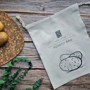 May include: A white cotton potato bag with black text that reads "NEW LIVING POTATO BAG" and a black and white illustration of potatoes.