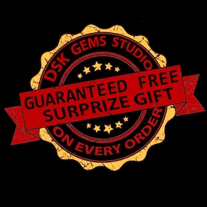 May include: A yellow and red distressed circular stamp with the text "DSK GEMS STUDIO" and "GUARANTEED FREE SURPRISE GIFT ON EVERY ORDER".