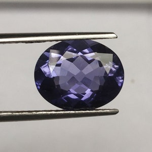 May include: A round, faceted, purple gemstone with a high polish.