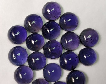 May include: A group of 16 round, purple gemstones, each measuring 7 mm in diameter. The gemstones are arranged in a circular pattern on a white surface.