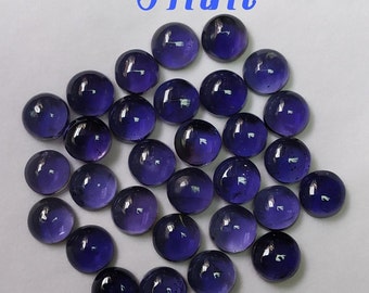 May include: A group of 25 round, 5 mm, dark purple cabochon gemstones.