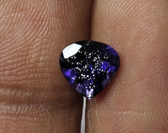 May include: A heart-shaped, dark purple gemstone with a sparkly, iridescent finish.