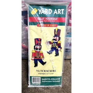 May include: A clear plastic package containing a "Yard Art" DIY pattern for Nutcrackers. The pattern is 43" x 41" and features two cartoon nutcracker soldiers in red, blue, and gold uniforms. The package text reads "Simple & Easy" and "Easy-to-Follow Instructions Included."