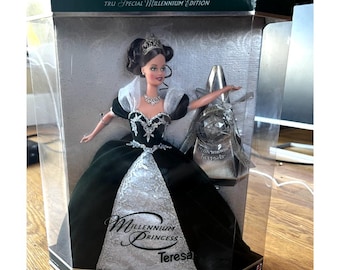 May include: A boxed "TRU Special Millennium Edition" Teresa doll. The doll wears a black and silver gown with a tiara and necklace. The box has the words "Millennium Princess Teresa" on the front.