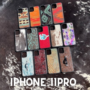 May include: A collection of 14 iPhone 11 Pro phone cases featuring a variety of designs. The cases are made from a range of materials, including cowhide, leather, and geometric patterns. The text "IPHONE 11 PRO" is displayed at the bottom of the image.
