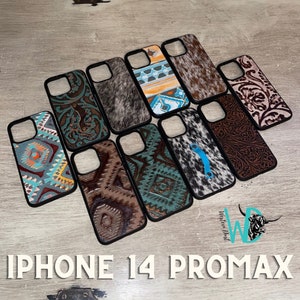 May include: A collection of ten iPhone 14 Pro Max phone cases featuring a variety of colourful and patterned designs. The cases are made from a range of materials, including leather, cowhide, and fabric. All cases are black and have a raised lip around the camera lens.