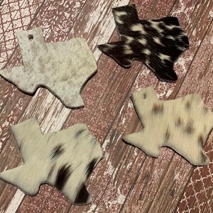 Puede incluir: Cuatro posavasos con forma de Texas hechos de piel de vaca en varios patrones de blanco y negro. Los posavasos est&aacute;n hechos de piel de vaca natural y tienen un estilo r&uacute;stico y del suroeste.