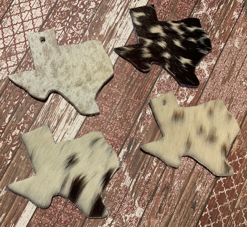 Puede incluir: Cuatro posavasos con forma de Texas hechos de piel de vaca en varios patrones de blanco y negro. Los posavasos est&aacute;n hechos de piel de vaca natural y tienen un estilo r&uacute;stico y del suroeste.