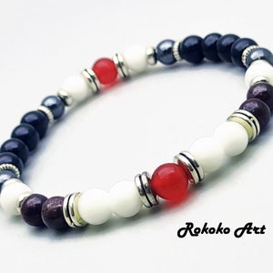 May include: A bracelet with black, white, red, and burgundy beads. The beads are separated by silver spacers. The bracelet is made of natural stones and is a great accessory for any outfit.