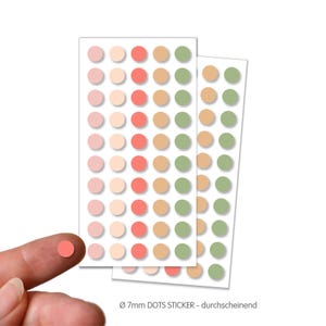 Könnte beinhalten: Zwei Bögen bunter Punktaufkleber. Jeder Bogen hat Reihen von gleichmäßig verteilten Punkten mit 7 mm Durchmesser in Rosa-, Pfirsich-, Korallen-, Beige- und Grüntönen. Der Text "Ø 7mm DOTS STICKER - durchscheinend" befindet sich unten.