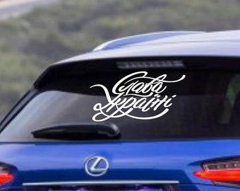 Może przedstawiać: Niebieski SUV Lexus NX 200t z białą naklejką winylową na tylnej szybie z napisem "Gotta Escape".