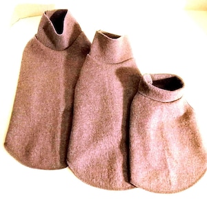 May include: Three brown turtleneck dog sweaters of varying sizes are arranged on a white surface. The sweaters are made of a soft, textured material and have a simple, classic design. The smallest sweater is approximately 10 inches long.
