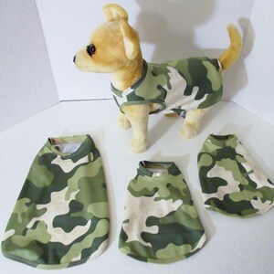 May include: Four camouflage dog shirts in different sizes. The shirts are green and tan with a camouflage pattern.