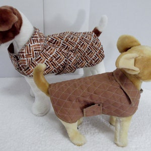 Peut inclure: Deux manteaux pour chien, l'un brun avec un motif matelassé et l'autre brun et blanc avec un motif géométrique.