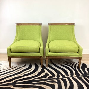 May include: Two lime green armchairs with wooden frames and legs. The chairs have a rectangular back with a curved top and a cushioned seat. The chairs are placed on a zebra-striped rug.