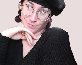 Könnte beinhalten: Eine schwarze Baskenmütze mit Fledermausflügeln, getragen von einer Person mit Brille. Die Baskenmütze ist aus weichem, flauschigem Material.