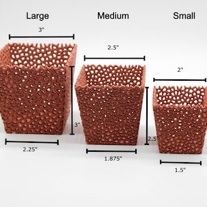 May include: Three terracotta-colored, square-shaped planters of varying sizes. The largest is 3 inches tall, 3 inches wide, and 2.25 inches deep. The medium planter is 3 inches tall, 2.5 inches wide, and 1.875 inches deep. The smallest is 2 inches tall, 2 inches wide, and 1.5 inches deep.