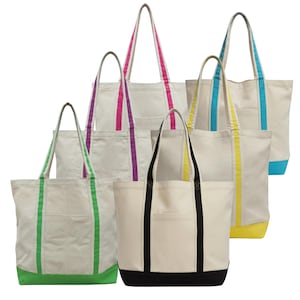 May include: A collection of canvas tote bags in various colors. The bags have a natural off-white color with colored accents on the handles and bottom. Colors include green, pink, purple, yellow, blue, and black. Each bag has a front pocket.