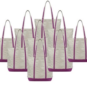 May include: A collection of canvas tote bags. The bags are off-white with a purple base and matching purple straps. Each bag has a rectangular shape with a pocket on the front.
