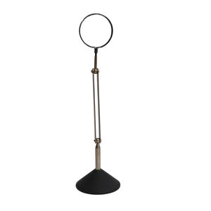 May include: A magnifying glass mounted on a tall, adjustable metal stand with a circular lens frame. The device features a slender, multi-jointed arm connected to a heavy, conical black base, allowing for vertical positioning and height adjustment.