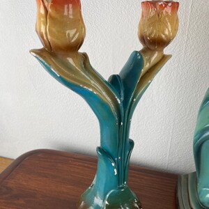 Peut inclure: Une paire de bougeoirs en c&eacute;ramique bleu sarcelle en forme de tulipes avec des t&ecirc;tes de fleurs jaunes et orange.