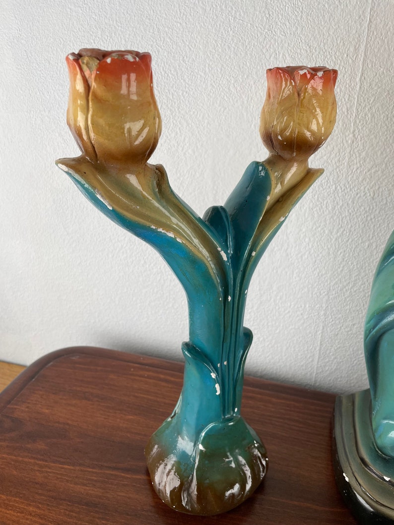 Peut inclure: Une paire de bougeoirs en c&eacute;ramique bleu sarcelle en forme de tulipes avec des t&ecirc;tes de fleurs jaunes et orange.