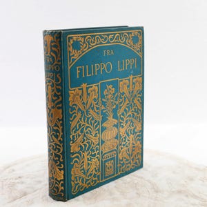 May include: A teal blue book with gold lettering and decorative designs. The title of the book is "Fra Filippo Lippi".