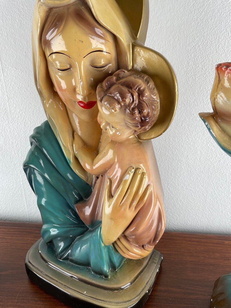Peut inclure: Une statue en pl&acirc;tre vintage de la Vierge Marie tenant un b&eacute;b&eacute; J&eacute;sus. La statue est peinte dans des tons de bleu, vert, jaune et rose.