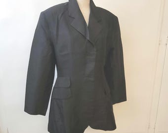May include: A black blazer with a long, fitted silhouette and a single button closure. The blazer has a pointed collar and two pockets on the front.